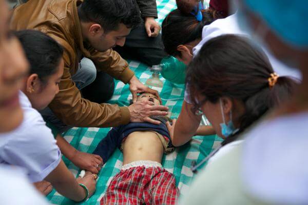 Workers struggle to save the life of a little boy pulled from the rubble. Photo - Patrick Adams